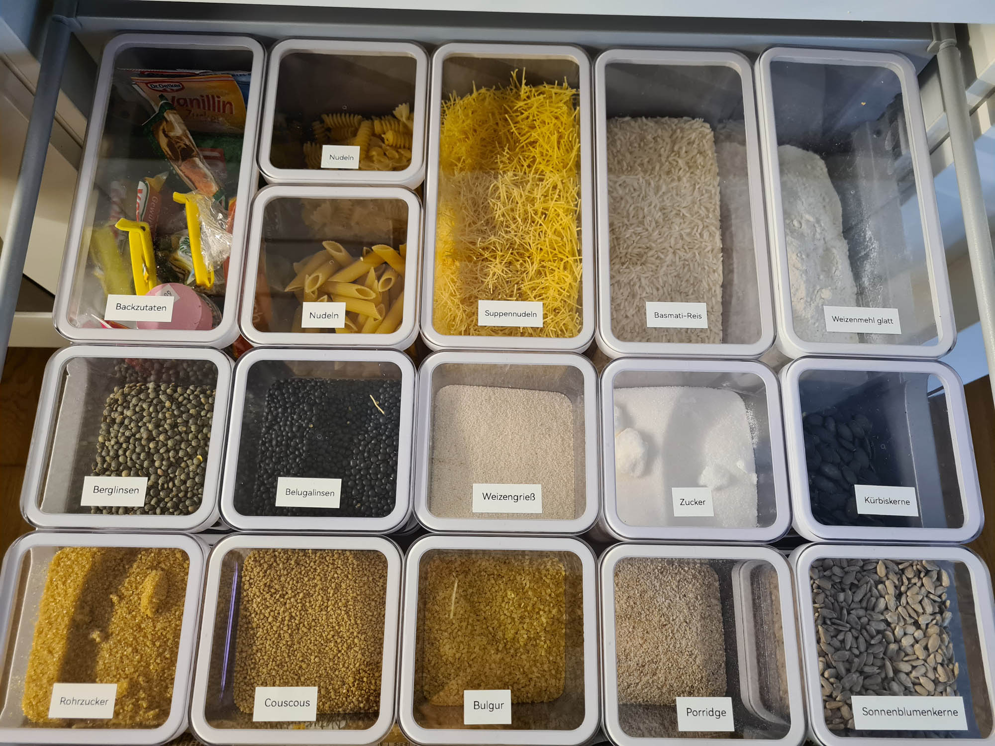 Nach dem Ordnungscoaching: Die Lebensmittel sind in durchsichtige Behälter gefüllt, platzsparend geschlichtet und übersichtlich beschriftet.